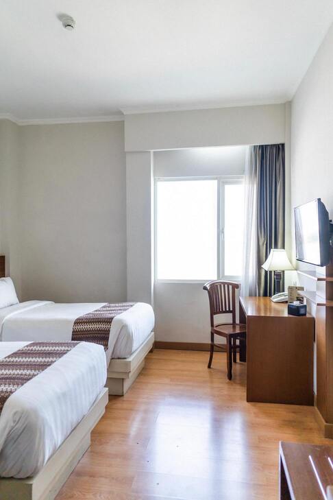 Photo de l'hôtel Chez Amina, c'est une chambre équipé d'une TV moderne, un bureau pour travail ainsi qu'un grand lit et enfin une fenêtre laissant beaucoup de lumière rentrer. 