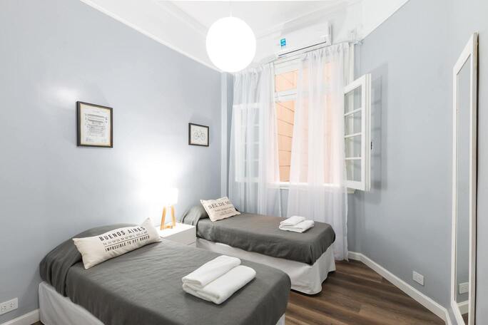 Photo de l'hôtel du port, on peut voir une chambre illuminé et moderne. C'est une chambre avec deux lits.